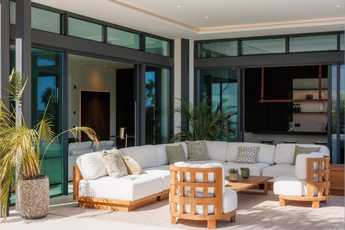 4OUR Villas – Marbella - covered outdoor terrace with white sectional sofa and teak armchairs