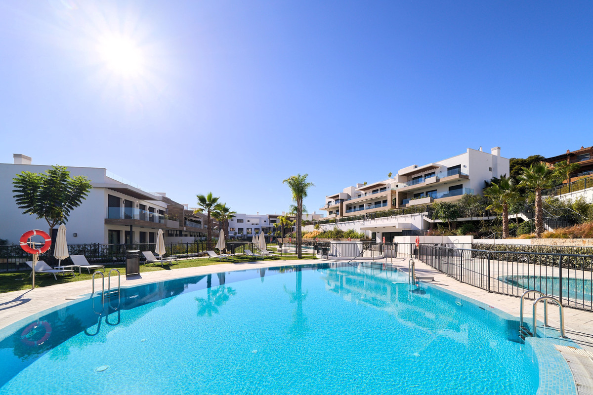 Atalaya Emotion – Estepona - outdoor communal pool with sun loungers and modern white apartment buildings on a hillside