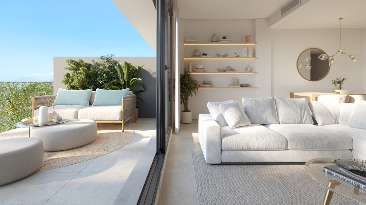 Blue Wave – Manilva - lichte open woonkamer met witte sofa, ingebouwde rekken en terras met zeezicht