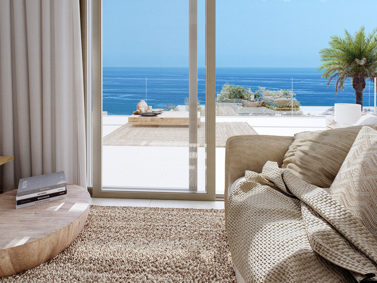 Calanova Homes – Calanova Golf - lichte woonkamer met vloer-tot-plafond schuifdeuren naar zonnig terras met panoramisch zeezicht