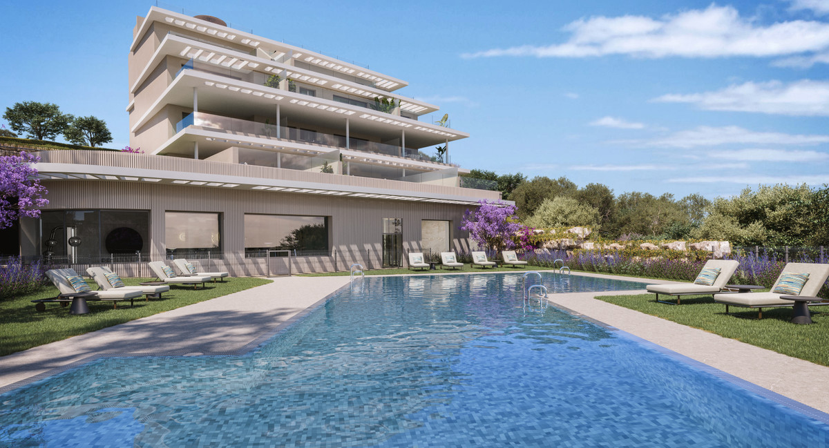 Capri – Fase 3 – Estepona - luxury outdoor swimming pool and lounge area with modern multi-storey residential building and lush gardens