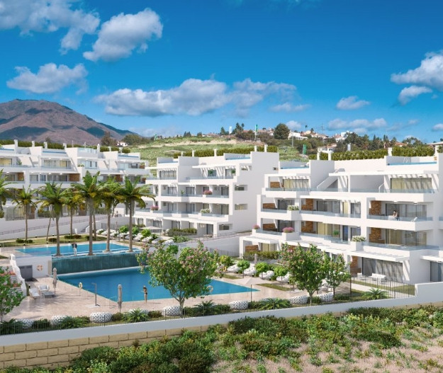 Costafiore Gardens – Fase 1 – Estepona - moderne hvid lejlighedskompleks med udendørs pool, palmetræer og bjergbaggrund