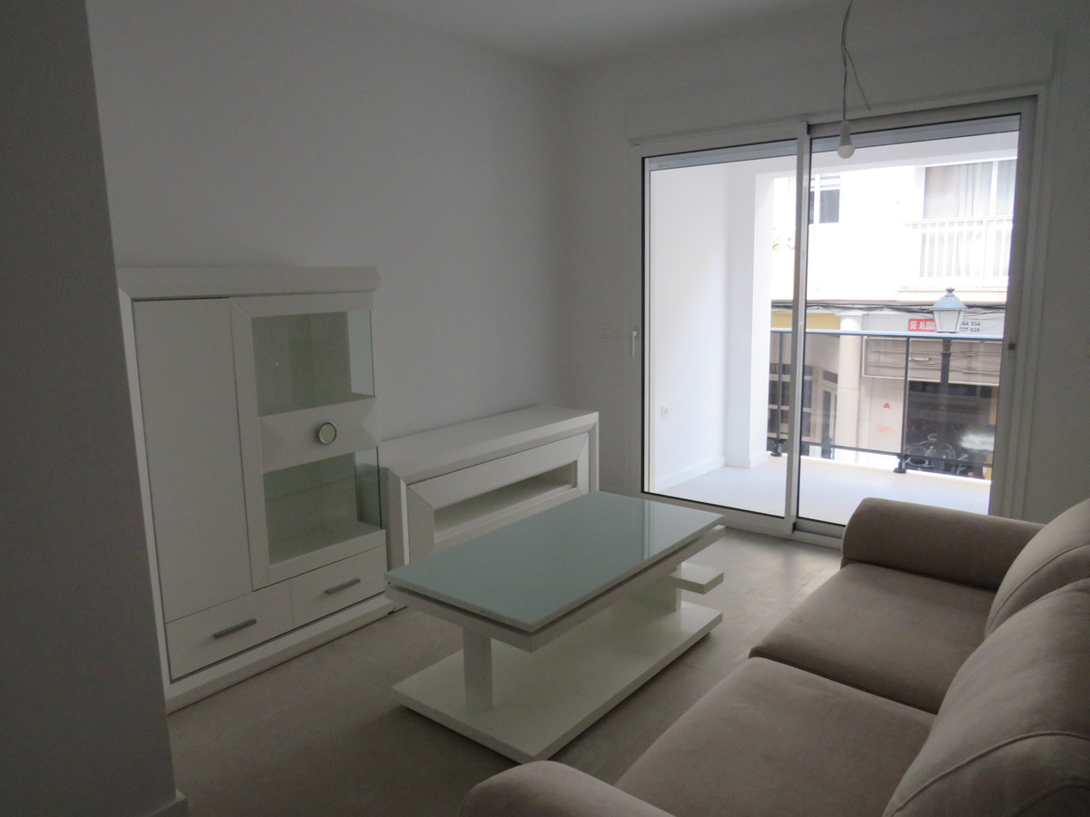 Edificio Venecia – Fuengirola - bright living room with white furniture, glass coffee table, beige sofa and sliding doors to balcony