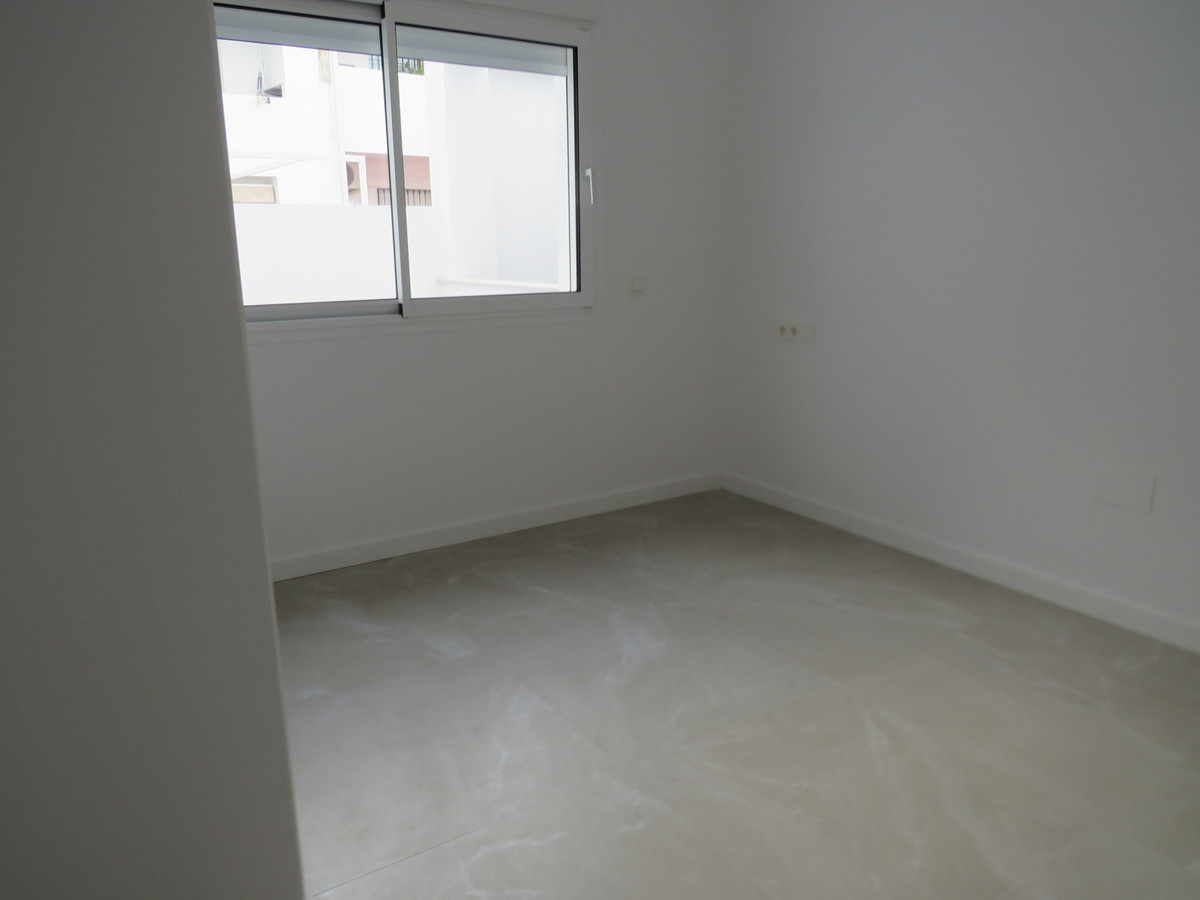 Edificio Venecia – Fuengirola - bright empty bedroom with tiled floor and window overlooking neighbouring building