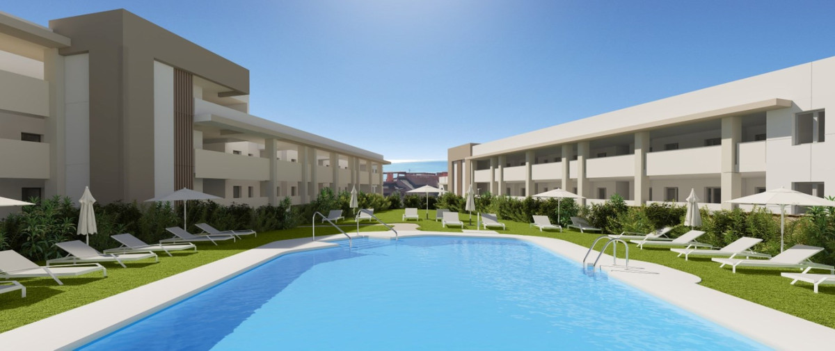 Grand Bay Apartments – Manilva - fælles swimmingpool og solterrasse omgivet af grønne haver og boligbebyggelse