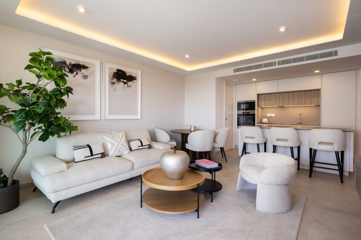Jade Tower with Furniture – Fuengirola - open-plan living room with cream sofa, round coffee table, bar stools and integrated kitchen