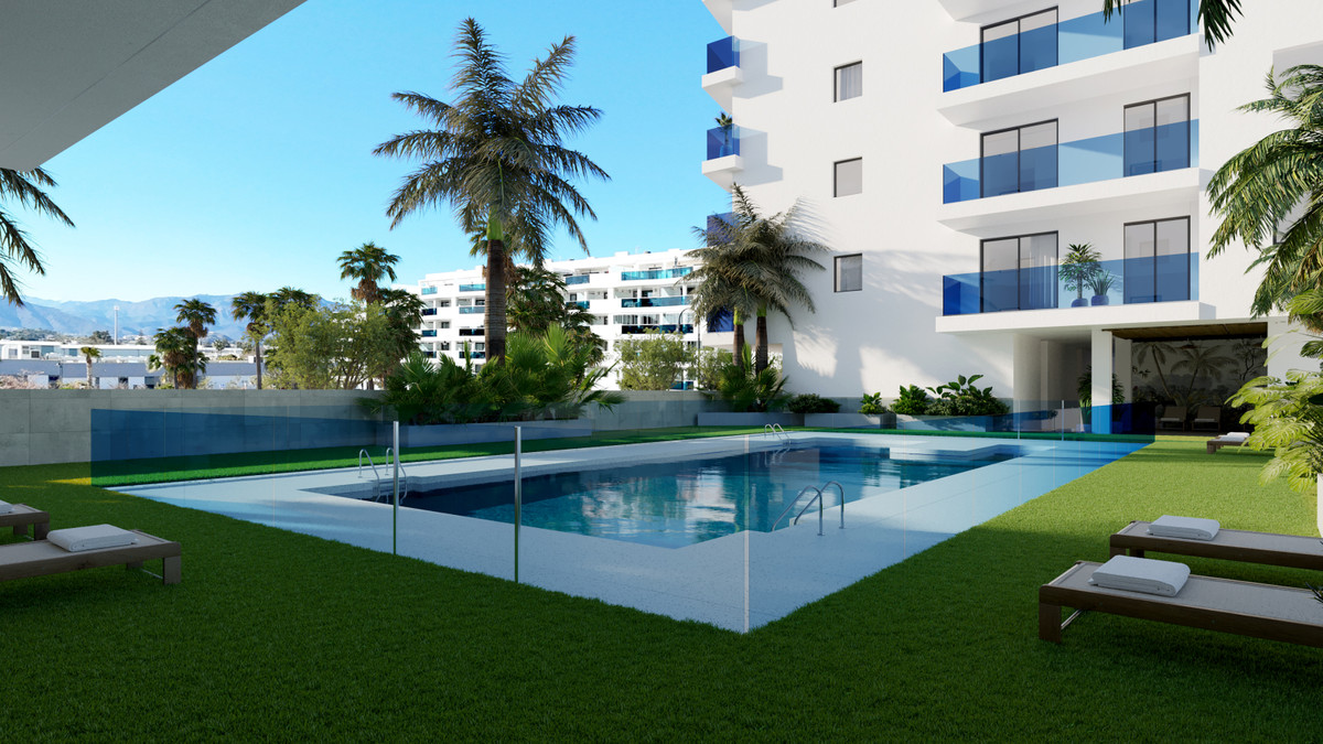 Laguna One – Las Lagunas - udendørs swimmingpool, velplejet græsplæne, palmetræer og hvide boligbygninger