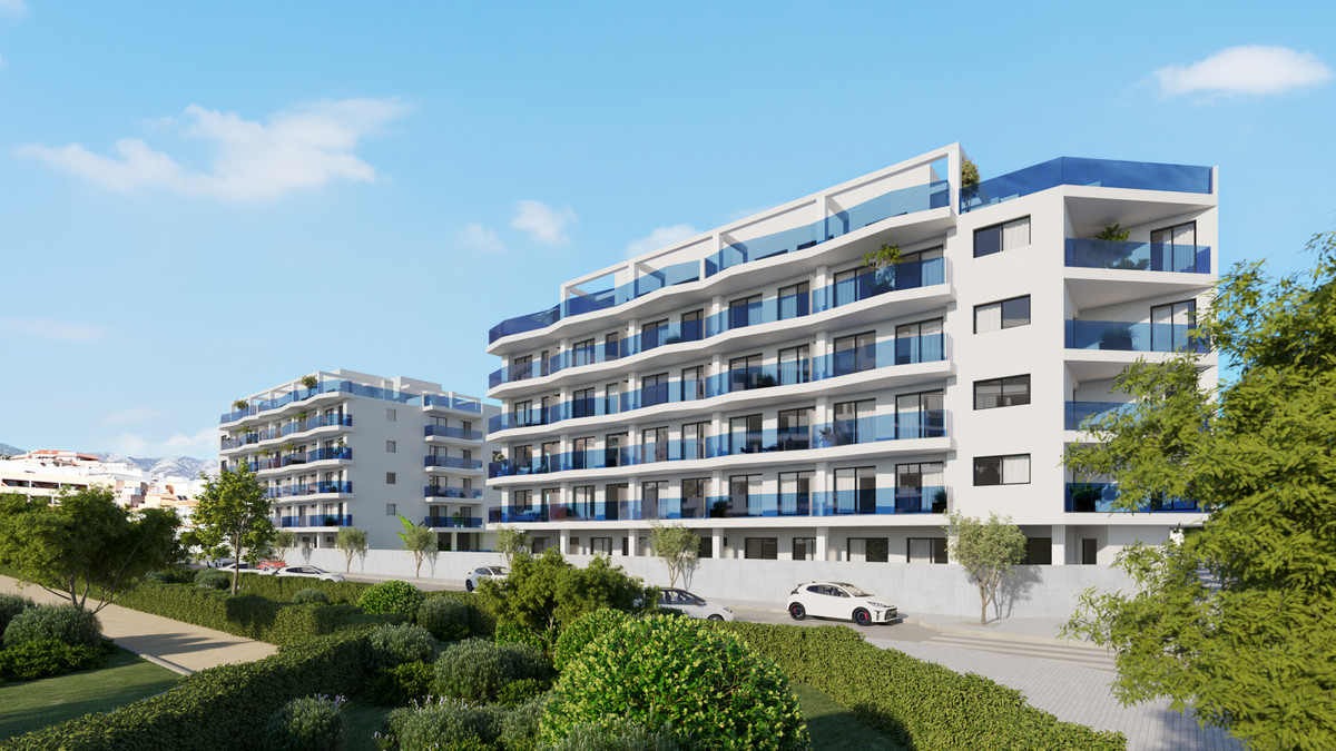 Laguna One – Las Lagunas - modernes weißes Wohngebäude mit blau verglasten Balkonen und gepflegten Gartenanlagen in Málaga