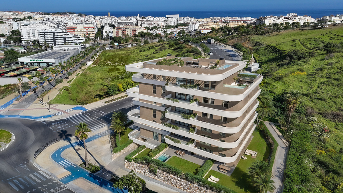 Looa Estepona – Estepona - aerial view of modern luxury apartment building with rooftop pool, terraces, and sea views