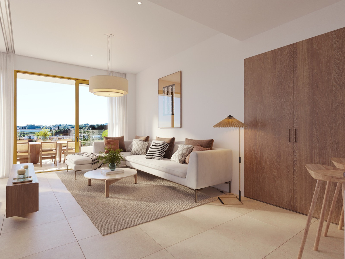 Luminal Homes – Fuengirola - lichte open woonkamer met witte bank, houten kast en panoramisch terrasuitzi­cht