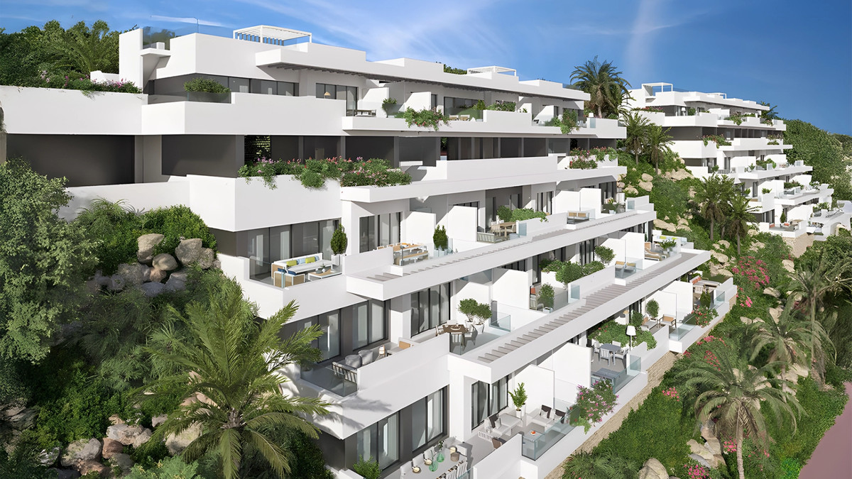 Navigolf Suites 2 – La Cala de Mijas - cascading white modern apartment complex built into a lush hillside with spacious terraces