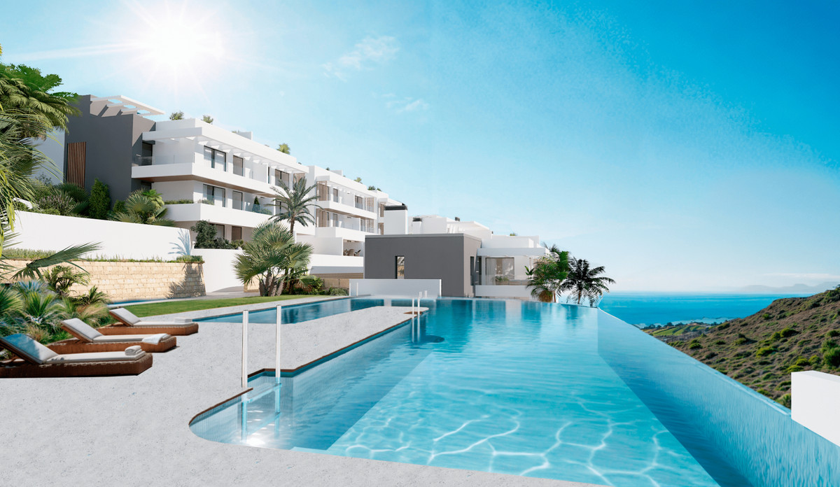 Nylva Homes – Manilva - infinity pool met zeezicht en modern wit appartementencomplex op een heuvel