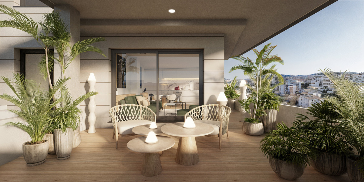Portamare – Estepona - sonnenverwöhnte Terrasse mit Korbstühlen, runden Holztischen, Tropenpflanzen und Panoramablick