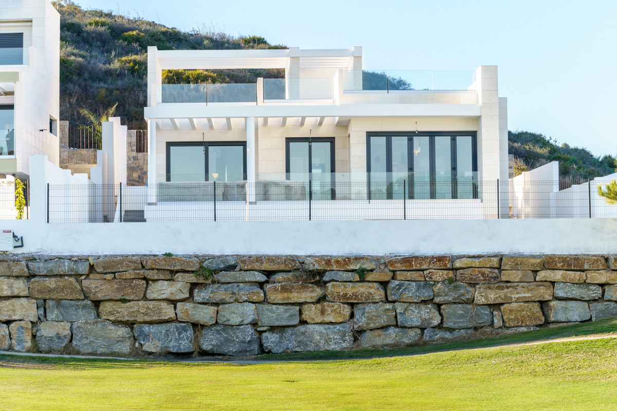 Residencial Mijas Costa – Mijas Costa - moderne hvid villa med store glasdøre, pergolaTerrasse og naturstensmuret ved en golffairway