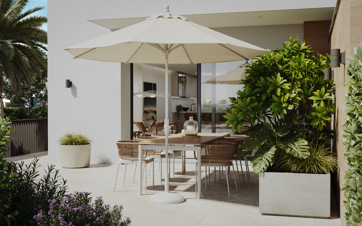 Santa Amalia – Fuengirola - beschat buitenterras met rotan stoelen, crème parasol en weelderige tropische beplanting