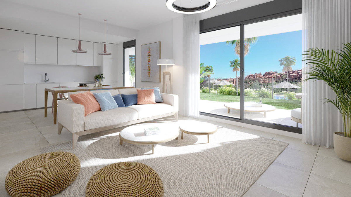 Serenity Gardens – Estepona - lyst åbent stue med hvid sofa, rattanpuffe og skydevægge til have og pool