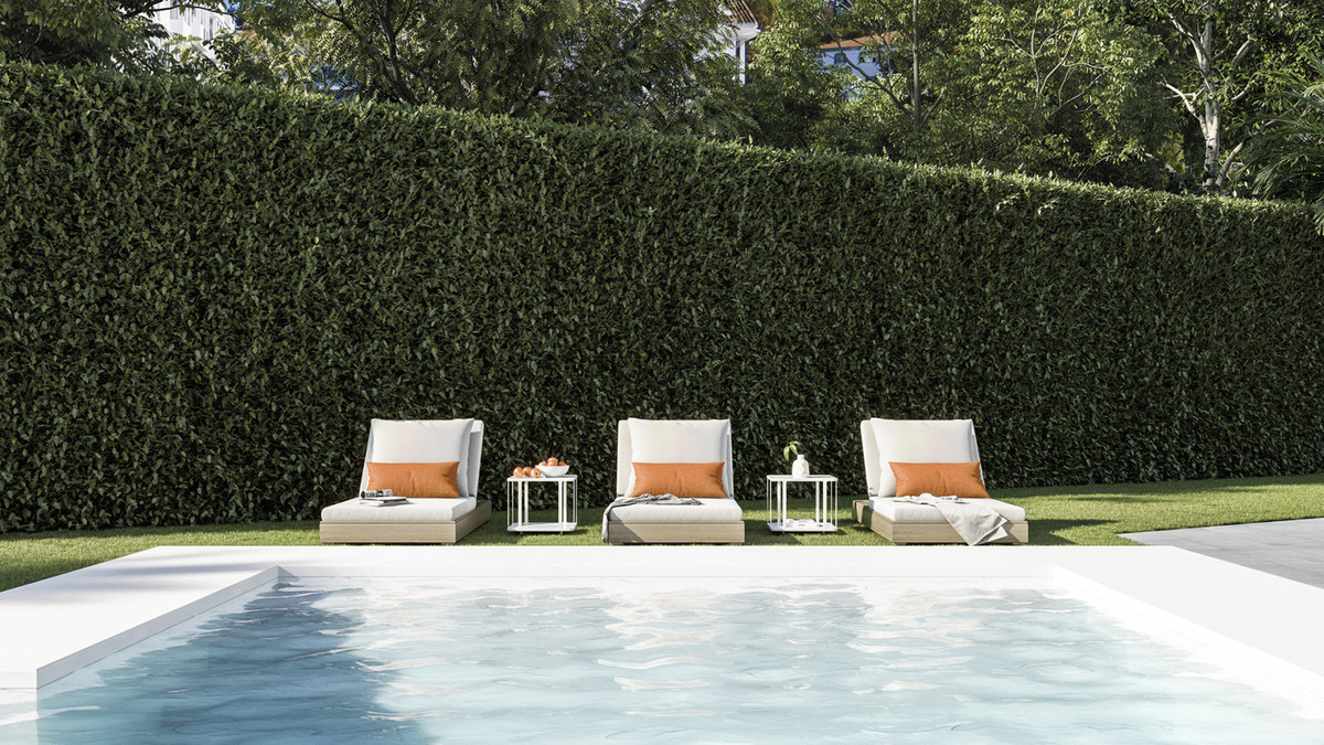Terrazas de Guadaiza I – Nueva Andalucía - luxury poolside sun loungers with orange cushions and tall green hedge