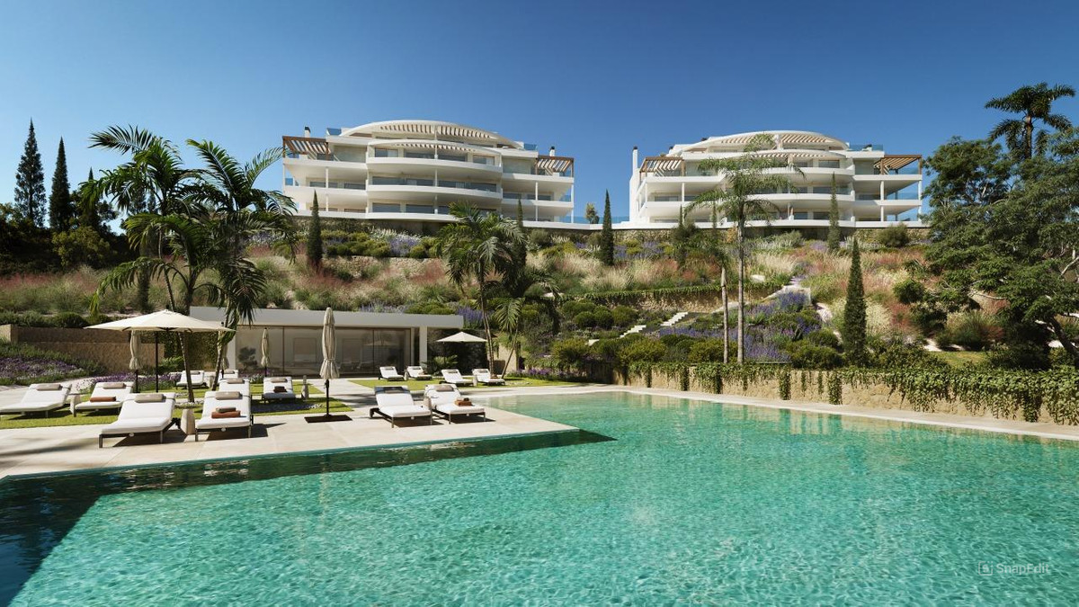 The Eagle Residences – Las Lagunas - luxe zwembadterras met ligstoelen, aangelegde tuinen op de heuvel en witte woongebouwen