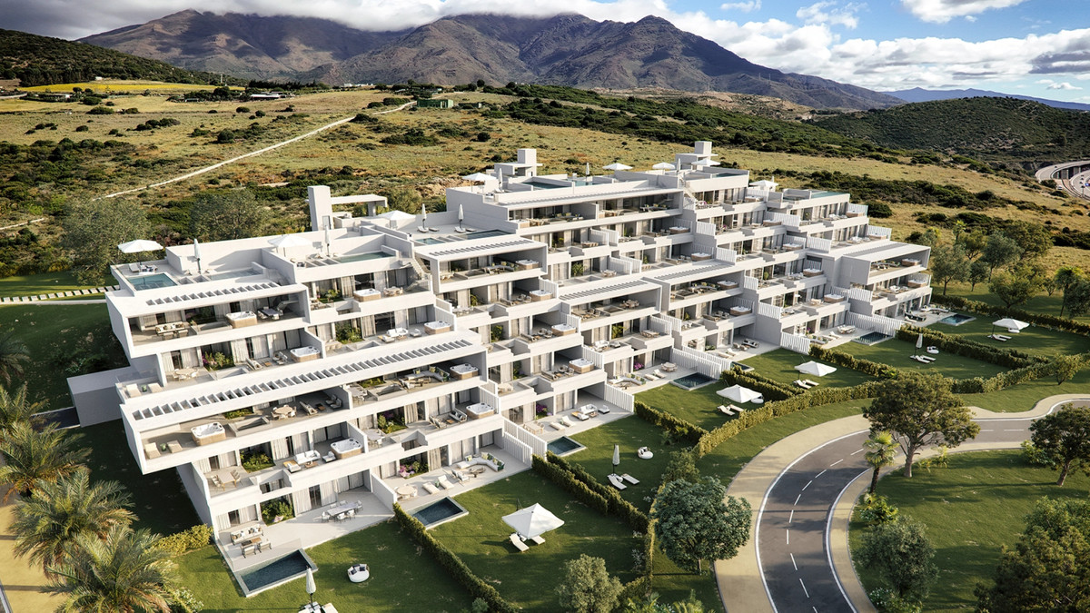The Place Alcazaba – Casares - aerial view of white modern apartment complex with terraces, pools and mountain backdrop