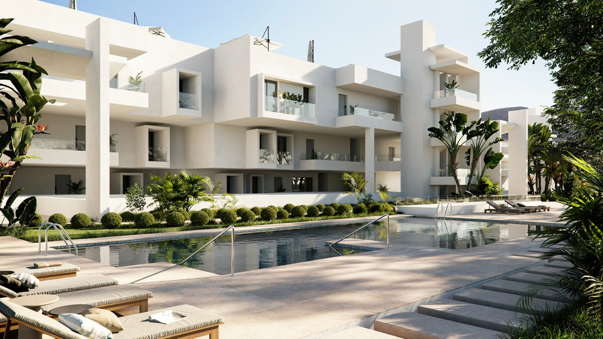 The Place Alcazaba – Casares - white modern apartment complex with communal pool, sun loungers and tropical landscaping