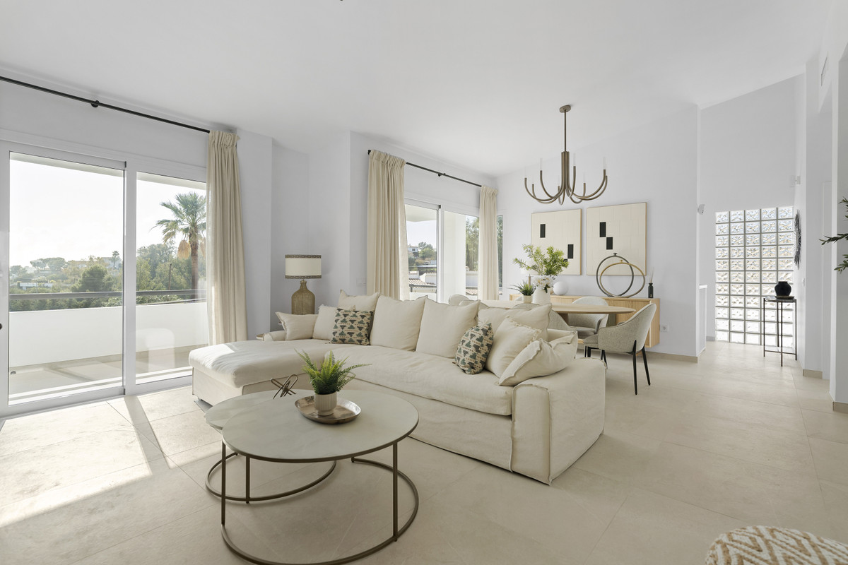 Urbanización Olimpo – Mijas - helles Wohnzimmer mit cremefarbenem Ecksofa, rundem Couchtisch, Kronleuchter und Balkonblick