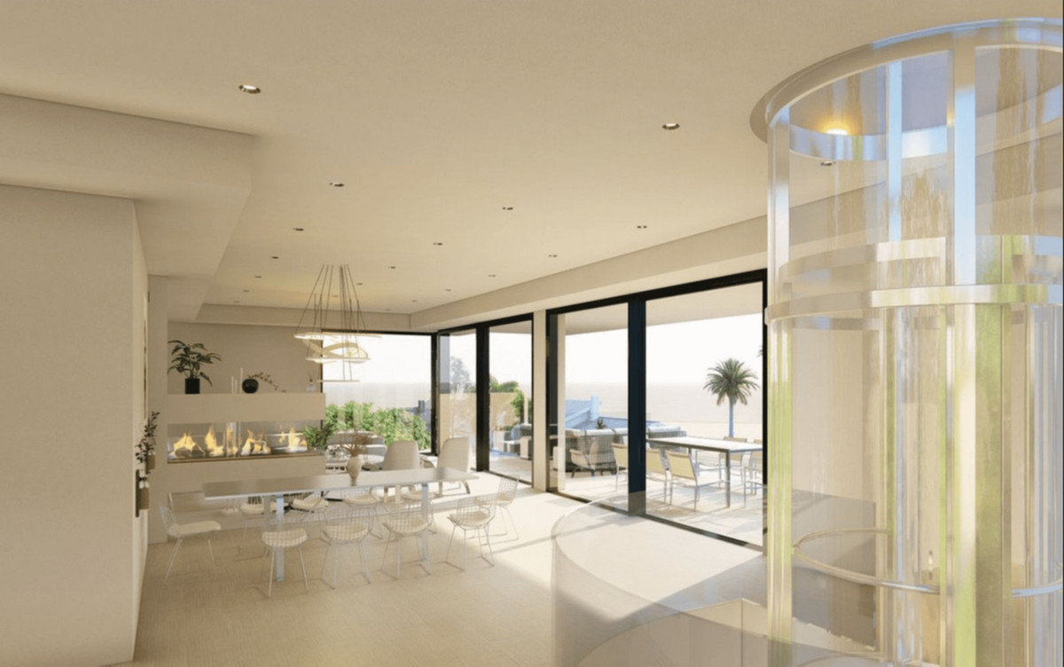 Villa 001 Marbesa – Marbella – heller offener Essbereich mit Glasaufzug, Kamin und Schiebetüren zur Terrasse