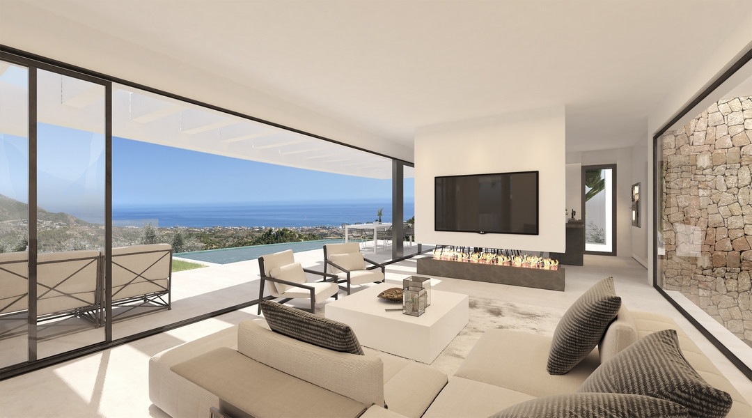 Villa La Ermita – Mijas - bright open-plan living room with floor-to-ceiling glass, fireplace, and panoramic sea views