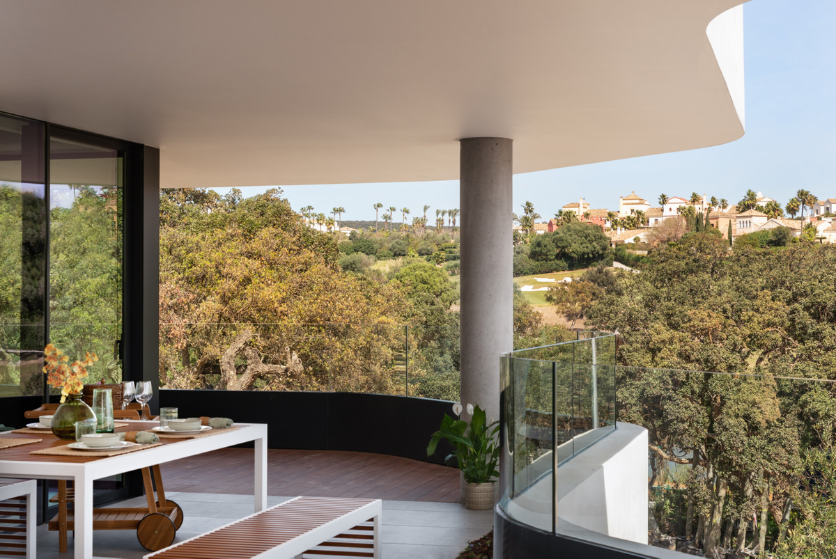 Village Verde – Sotogrande - gebogen terras met eethoek en panoramisch uitzicht op de golfbaan en boomtoppen