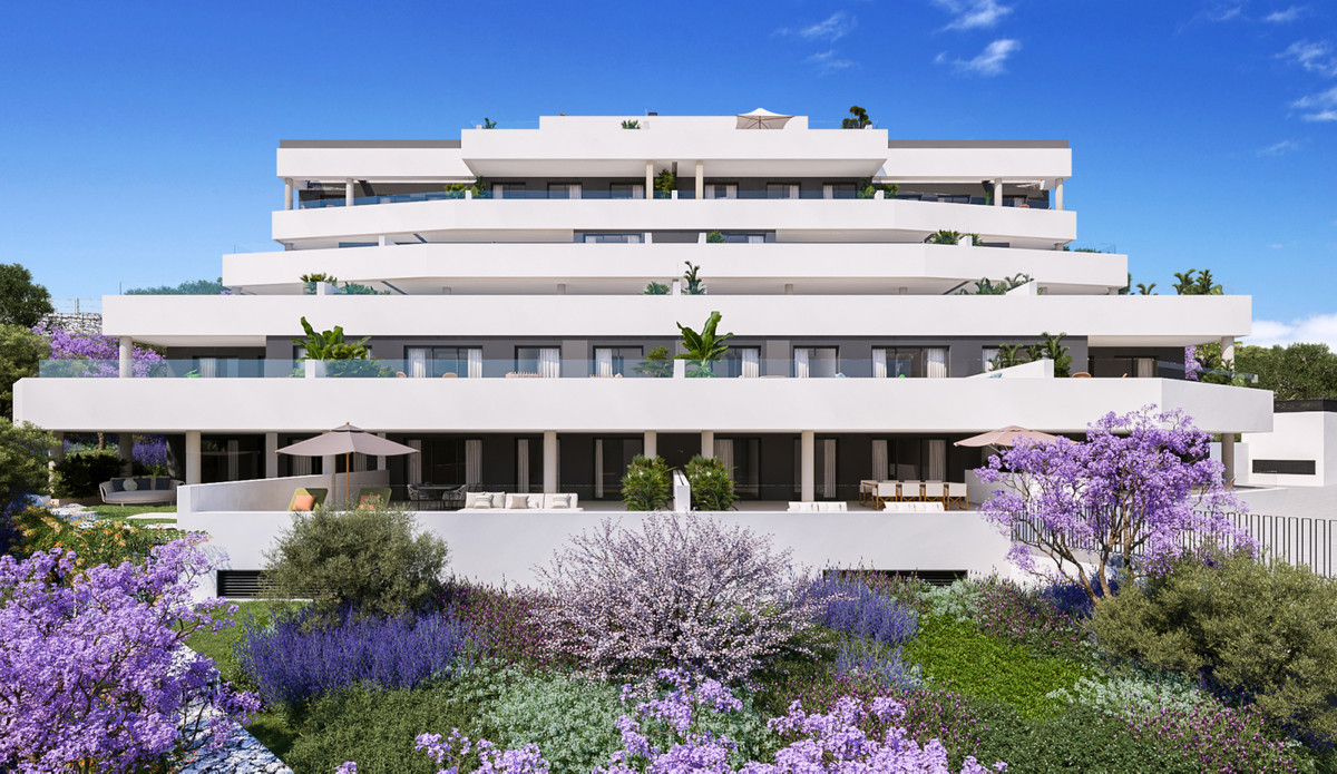 Medblue IV – Altos de los Monteros - moderne hvid terrassefacade omgivet af lilla jacarandatræer og frodige middelhavshaver