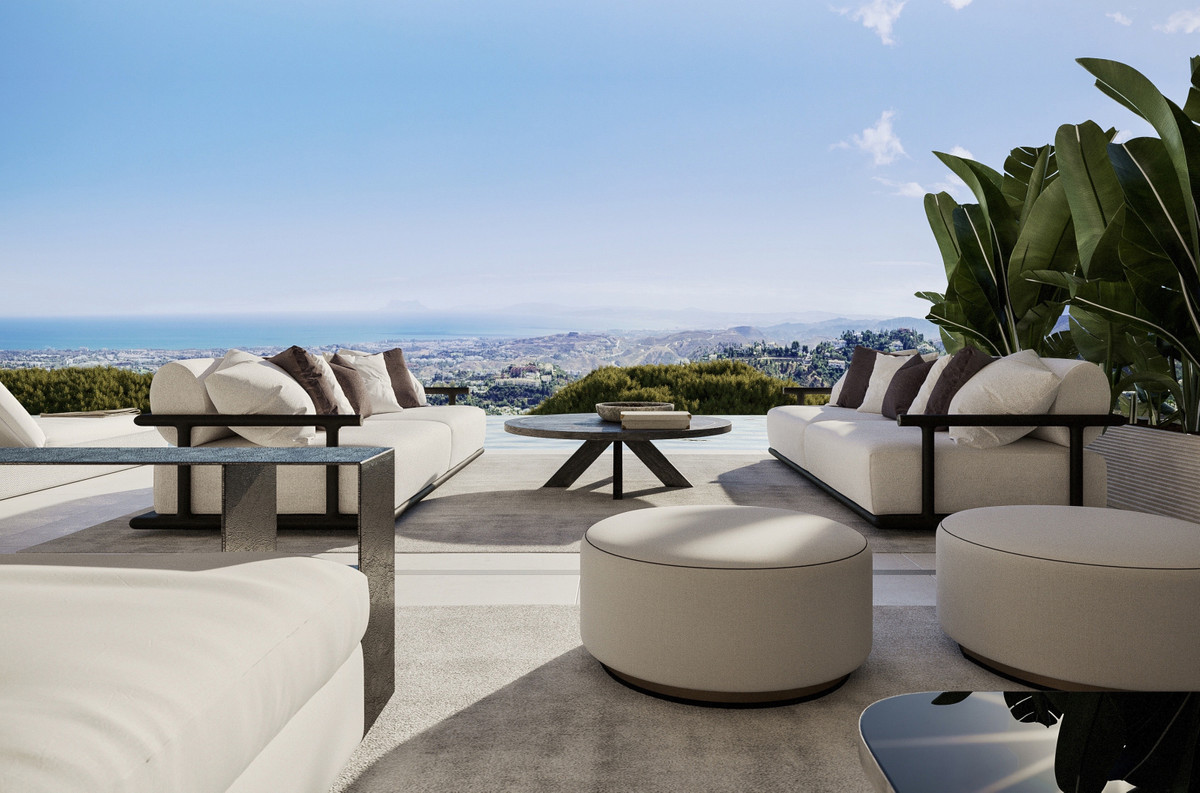 Vista Lago Residences – Benahavís - luksuriøs terrasse med cremefarvet sofaer, ottomaner og panoramaudsigt over hav og bjerge
