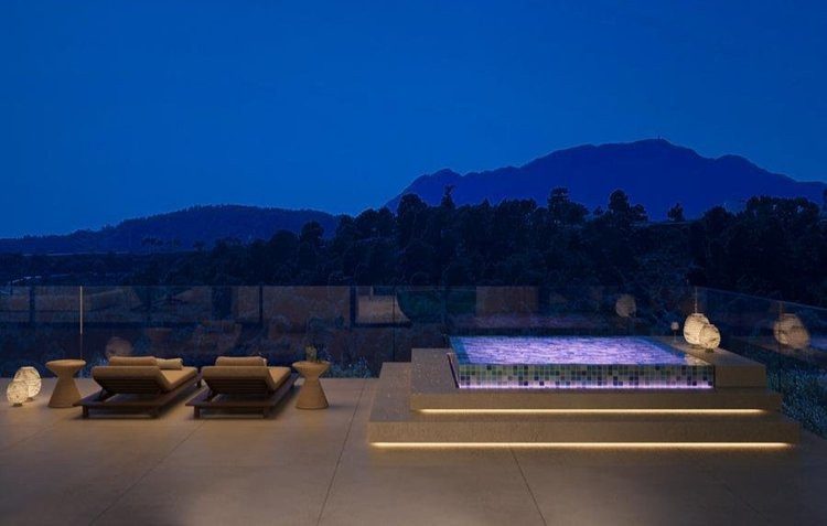 Villa Maximus – Benahavís - tagterrasse med oplyst boblebad, solsenge og bjergpanorama i skumringen
