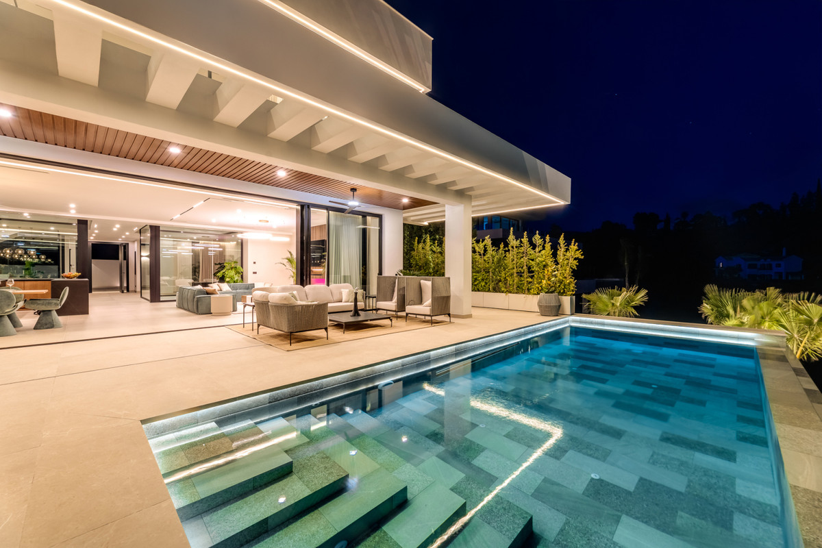 Villa Alfa – El Madroñal - oplyst udendørs pool og overdækket terrasse med åben stue om natten