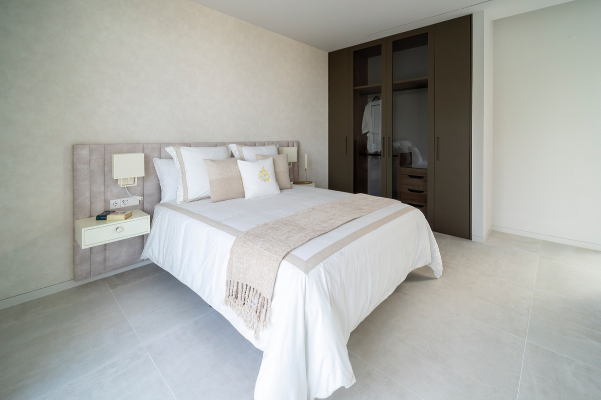 Villa Esmeralda – El Paraiso - elegante slaapkamer met gestoffeerd hoofdbord, witte beddengoed en ingebouwde donkere kledingkast