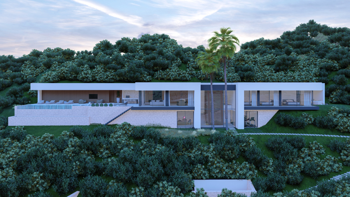VILLA E20 – KEY READY – Benahavís - buitengevel met overloopzwembad, palmbomen en weelderige heuvels in de schemering
