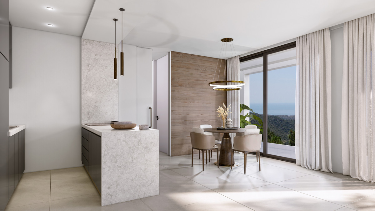 VILLA EVANIA – Benahavís - open keuken en eethoek met marmeren eiland, warme houten accentwand en panoramisch zeezicht