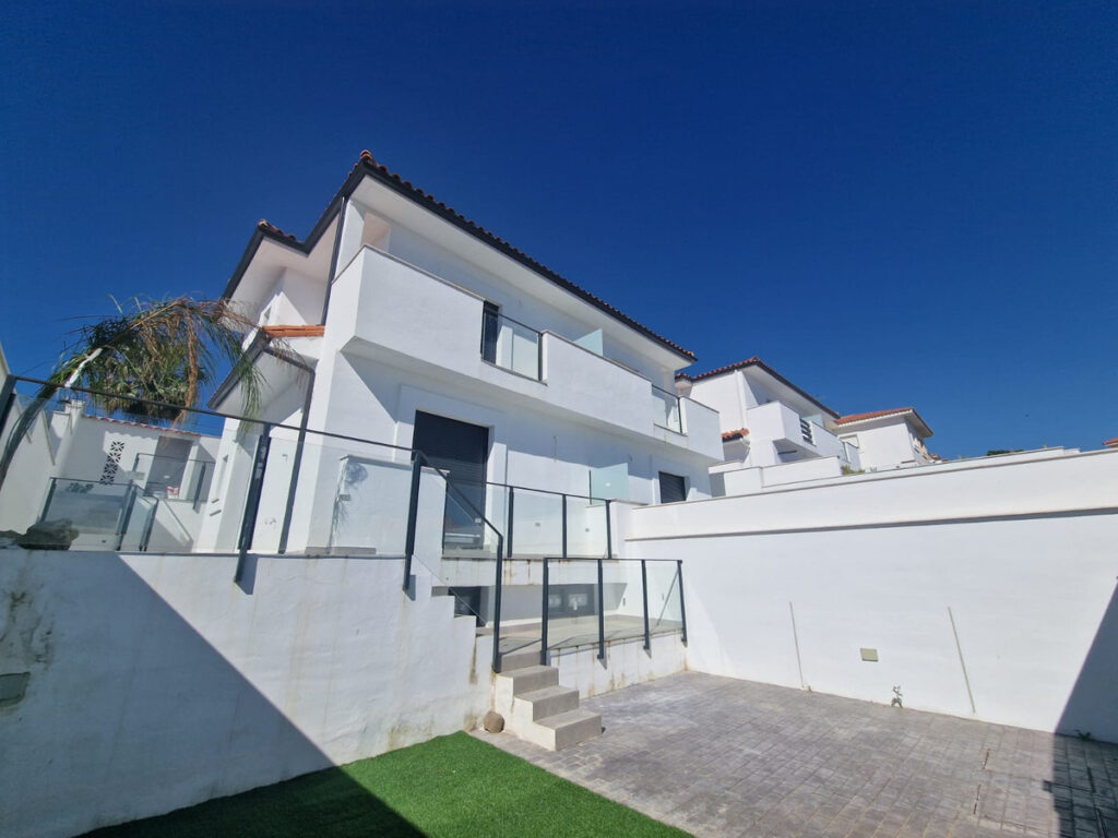 Casas Pareadas y Villa Aldea Hills – Manilva - modern white two-storey exterior with glass railings, steps and paved courtyard under deep blue sky