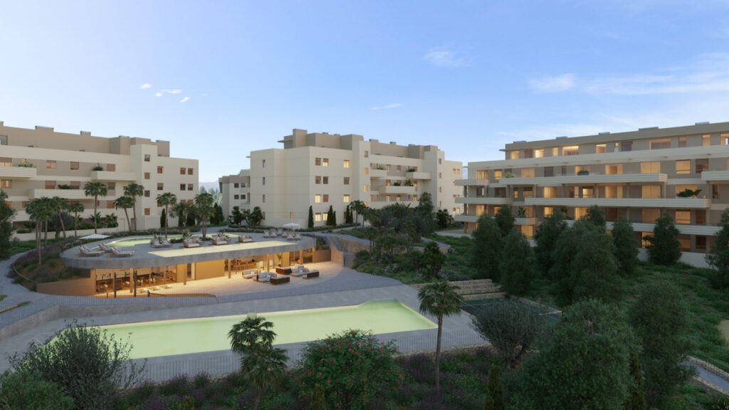 Greenity – Mijas - luxury residential complex with pool, landscaped gardens and illuminated apartments at dusk