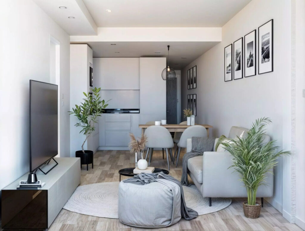 Medhills Fuengirola – Fuengirola - modern open-plan living and dining area with grey sofa, pouf, plants and kitchen beyond