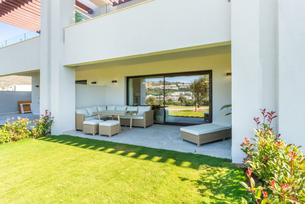The Meadows – FASE 1 – La Cala Golf - covered terrace with wicker lounge furniture, sun lounger, and garden views