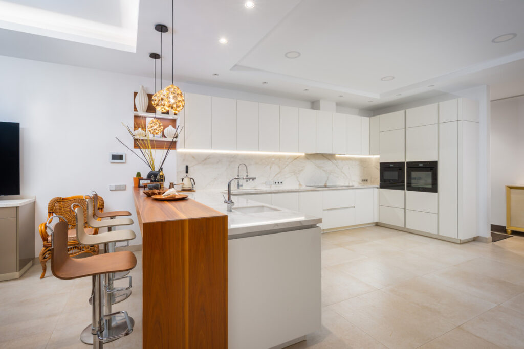Villa Murcia - Estepona - modern open-plan kitchen with white cabinetry, marble backsplash, and wooden island bar