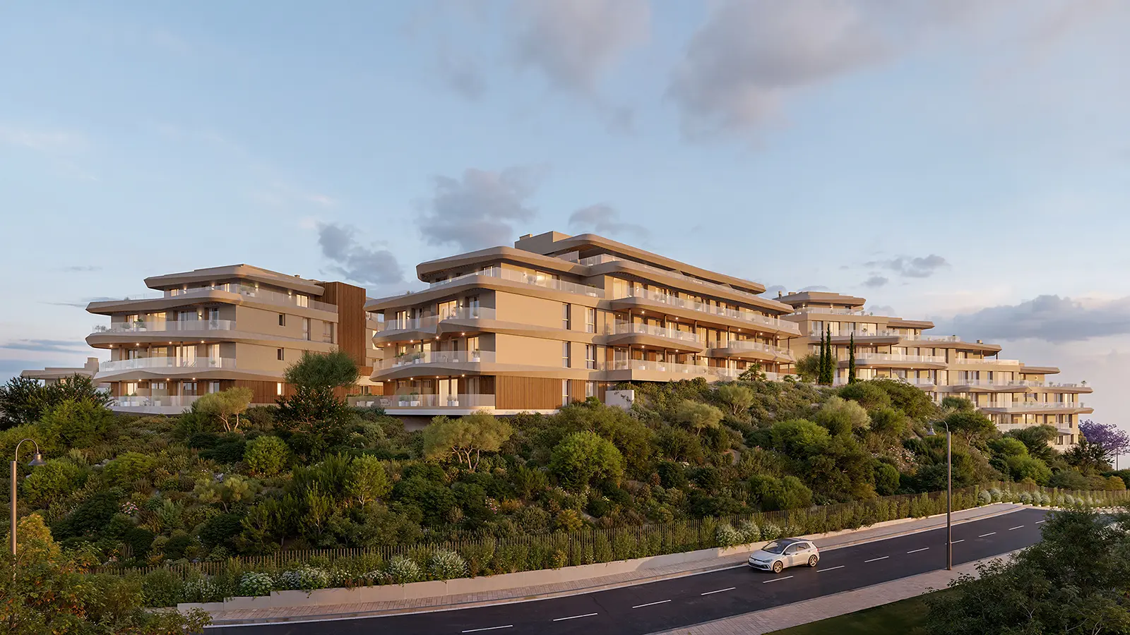 Vission Hills exterior at dusk, four light-toned residential blocks with balconies amid greenery