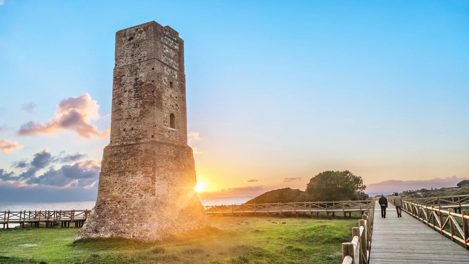 Vagttårnet Torre Ladrones og træbroen gennem Dunas de Artola ved Cabopino i solnedgang