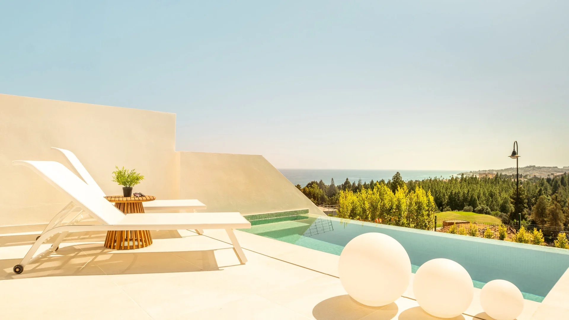En moderne villaterrasse med infinity-pool og havudsigt i El Chaparral