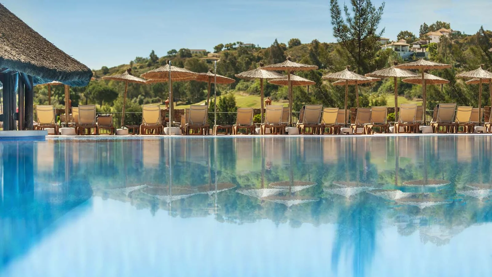Infinitypool og solsenge på La Cala Golf Resort med udsigt over golfbanen og bakkerne