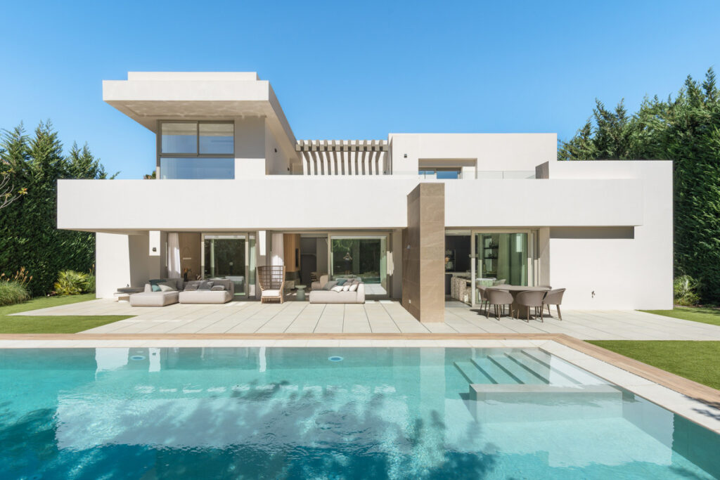 Nine in Paradise – Estepona - modern white villa exterior with large swimming pool and terrace seating area