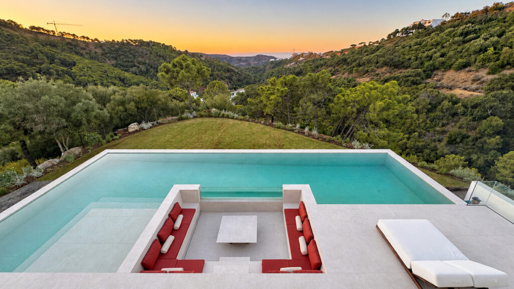THE PRIVILEGE VILLA A4 – Benahavís - infinity pool with sunken lounge seating, lawn, and valley sunset views