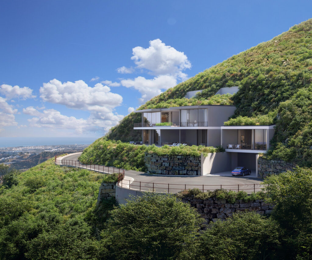 Vitae Villas C9 – Benahavís - hillside luxury villa exterior with green roof, glass facades, and winding mountain road